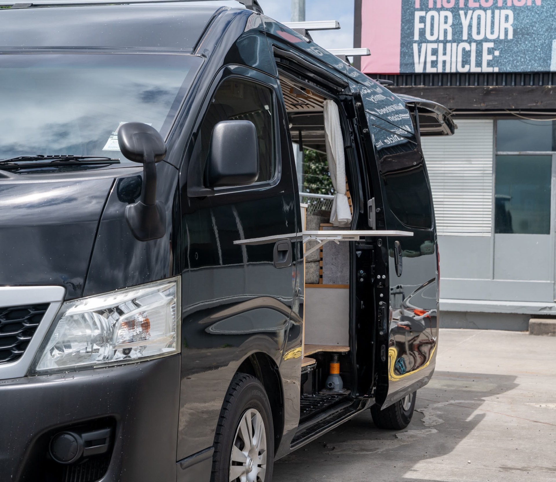 Black Nissan campervan side-open at the Only Camper Vans Auckland workshop